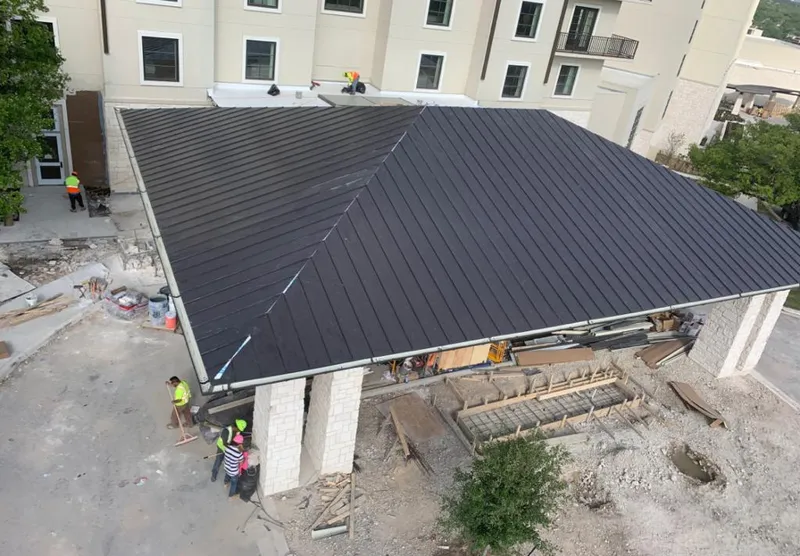 Metal roofing installation team working on a commercial building in Eaton Rapids